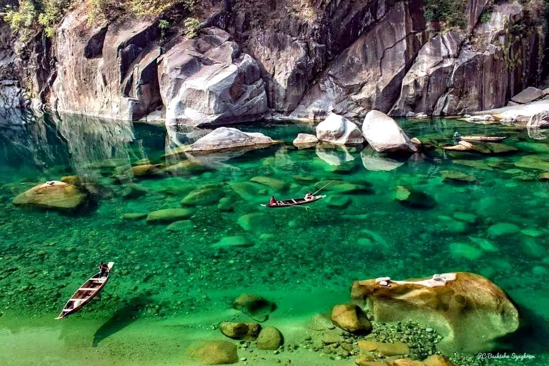 A boat resting on the glass-clear green water of the Dawki river, Meghalaya
