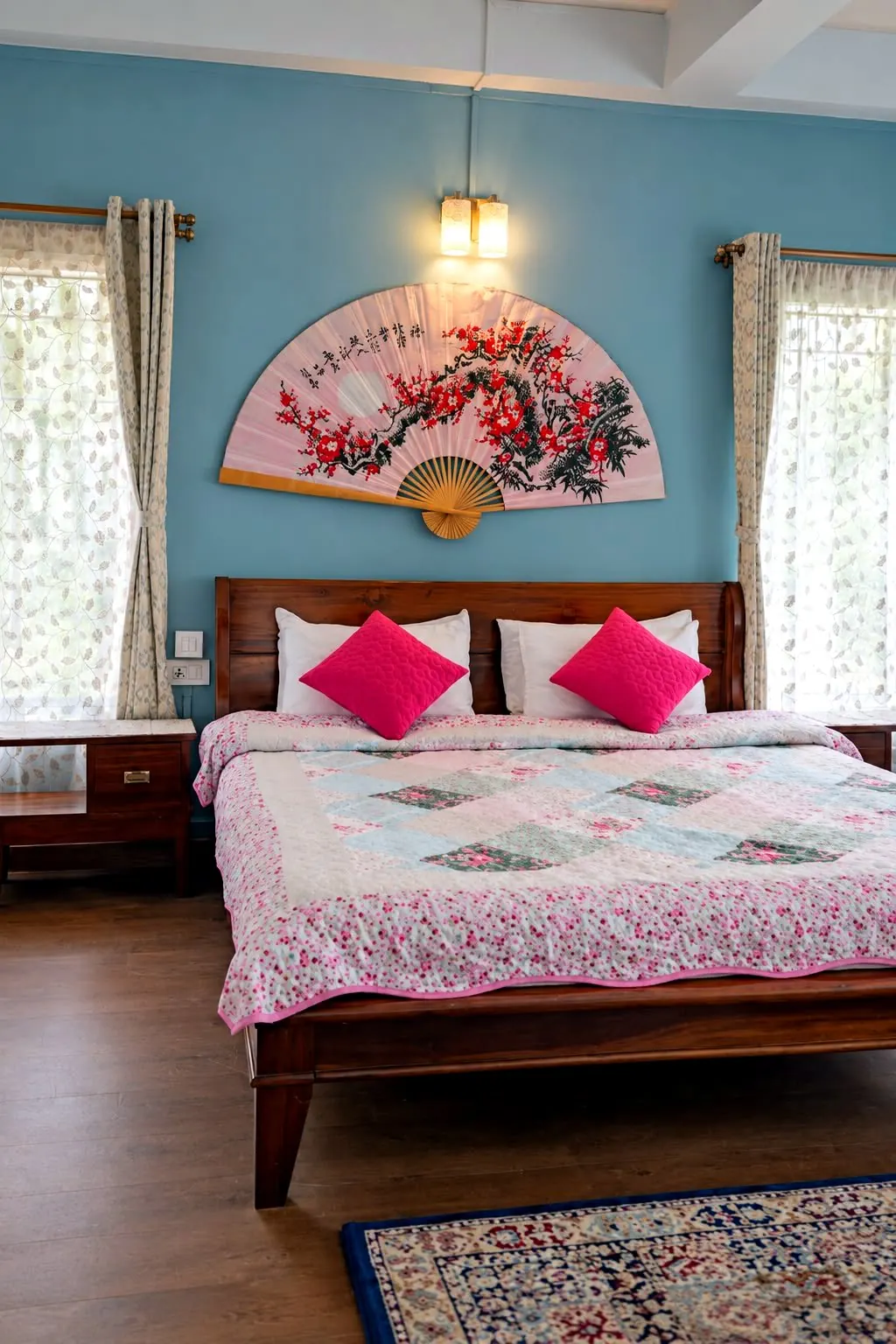 Orchid room with dusty blue walls, a dark wood bed and a large pink blossom-painted fan